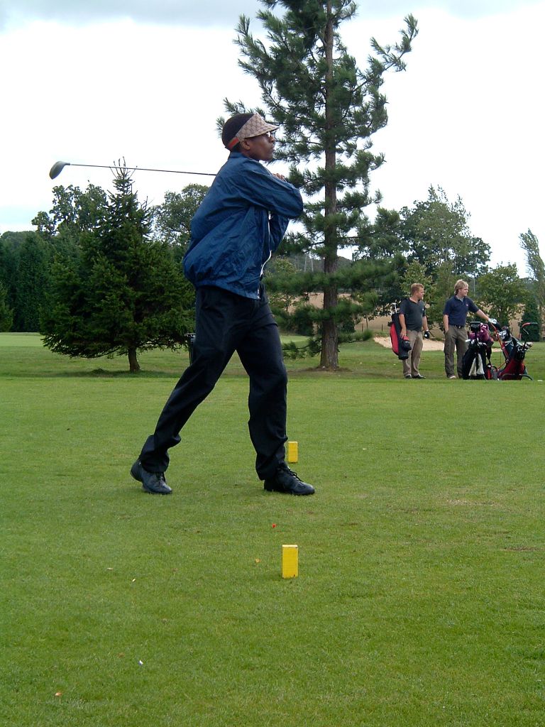 Jabunong driving off the tee in blue jacket, full follow-through